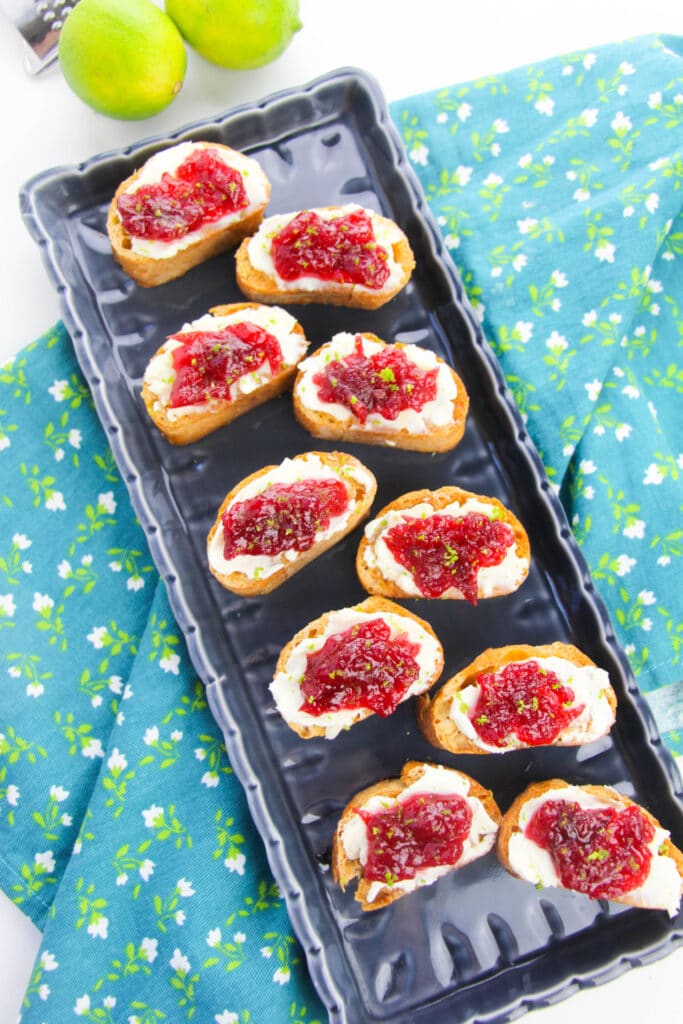 cranberry crostini on tray with blue flower background