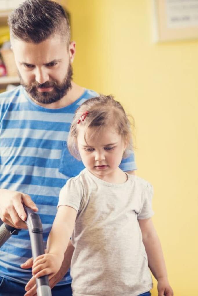 father teaching daughter a chore