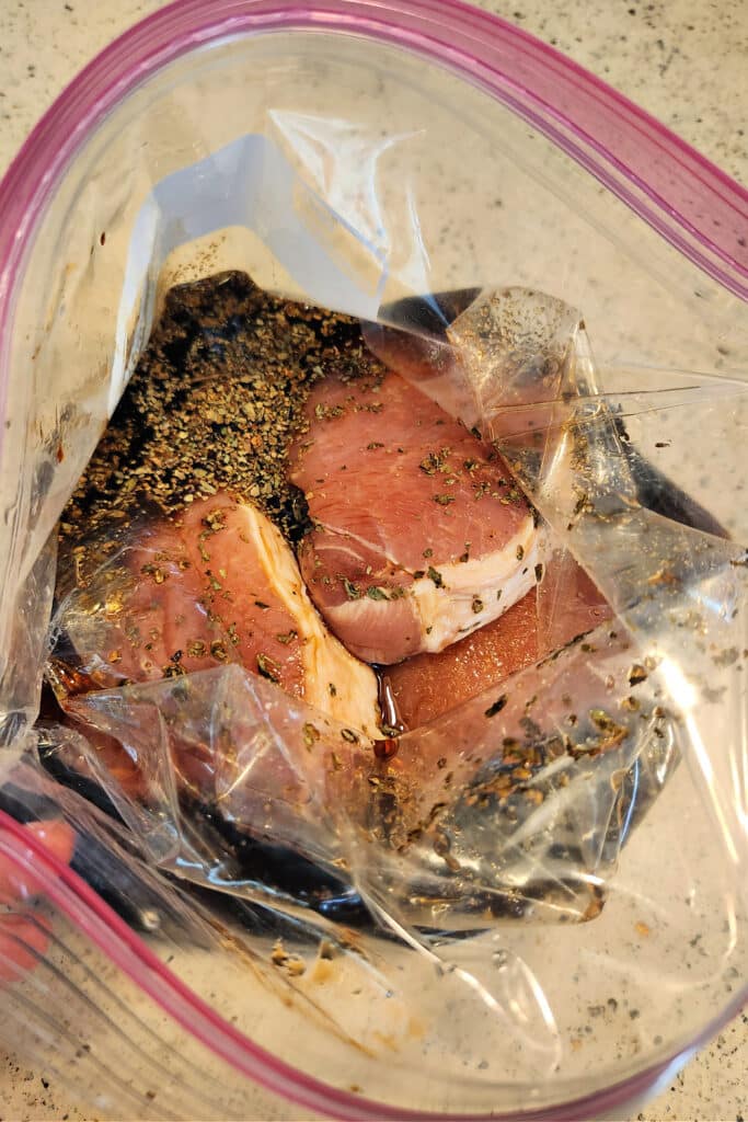 salt and pepper pork chops soaking in brine in airtight zipper bag