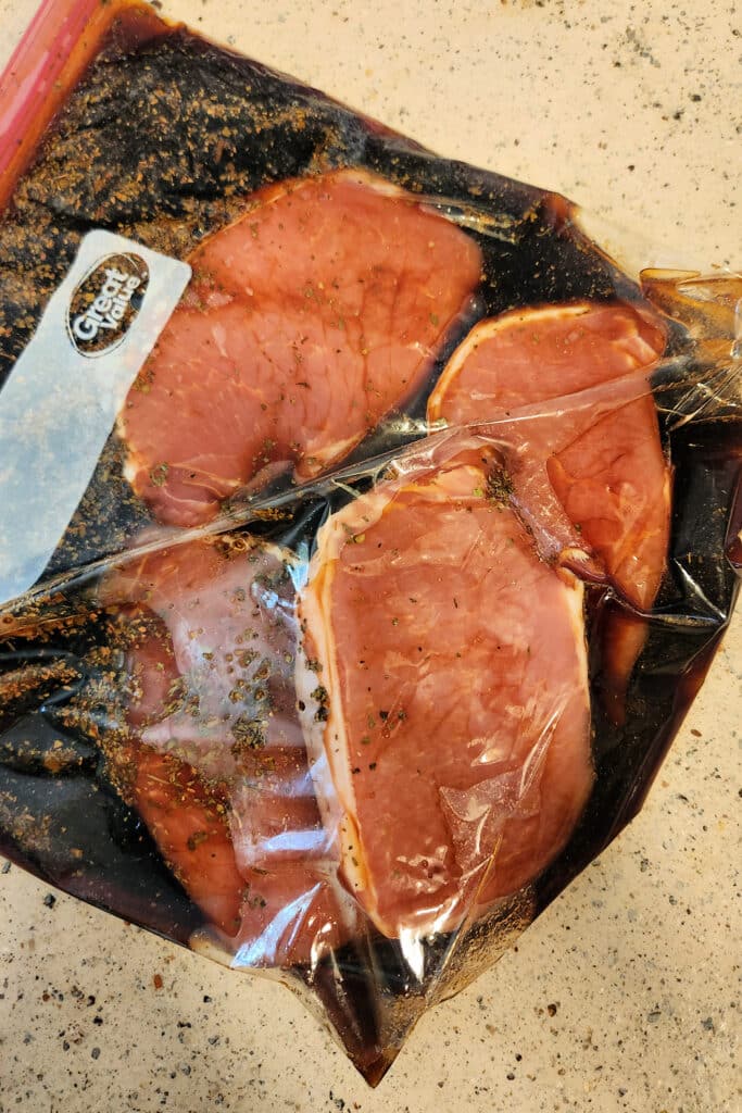 salt and pepper pork chops soaking in brine in zipper bag