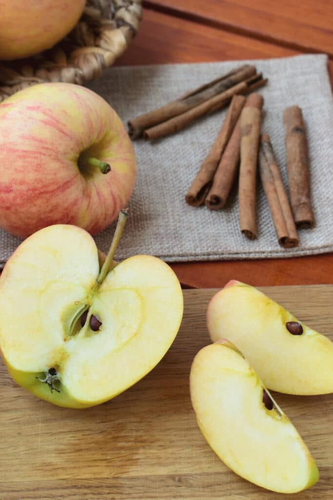 sliced apples for apple butter with cinnamon sticks