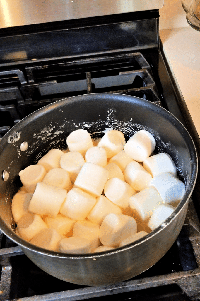 Adding marshmallows to pan on stovetop