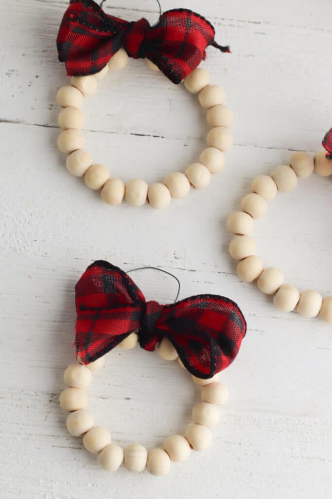 Adding ribbon to bead ring. Pictured three wooden bead cirlces