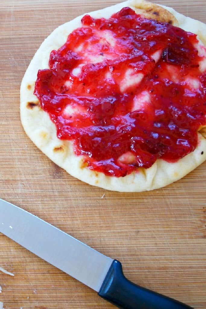 Spread cranberry sauce over flatbreads