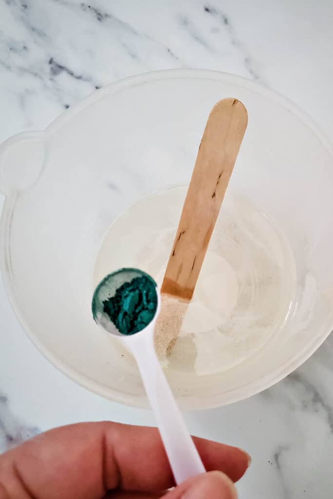 adding coloring to soap melted glycerin in measuring cup