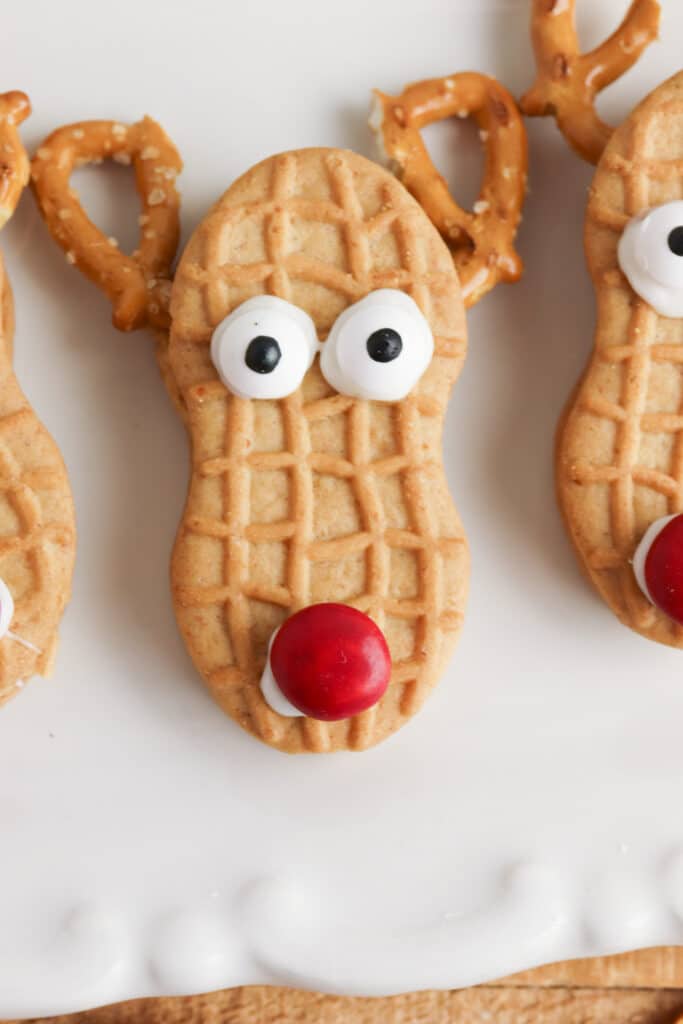 adding to candy eyes and nose to reindeer cookies