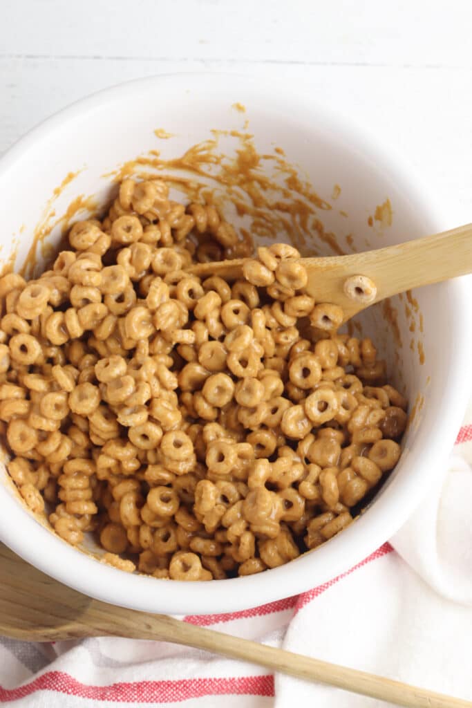 Mixing wet and dry ingredients for cheerio bars in large bowl