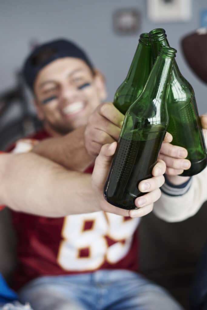 three glass bottles being clashed together in cheers formation