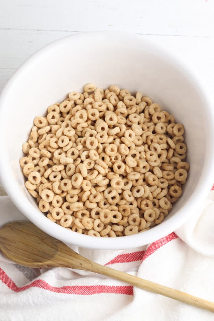 cheerio cereal in mixing bowl with wooden spoon