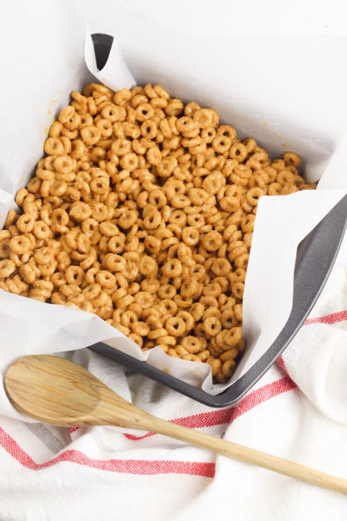 putting cheerio mixture in pan to harden