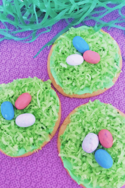 Easter cookies in puple background with green easter basket filler