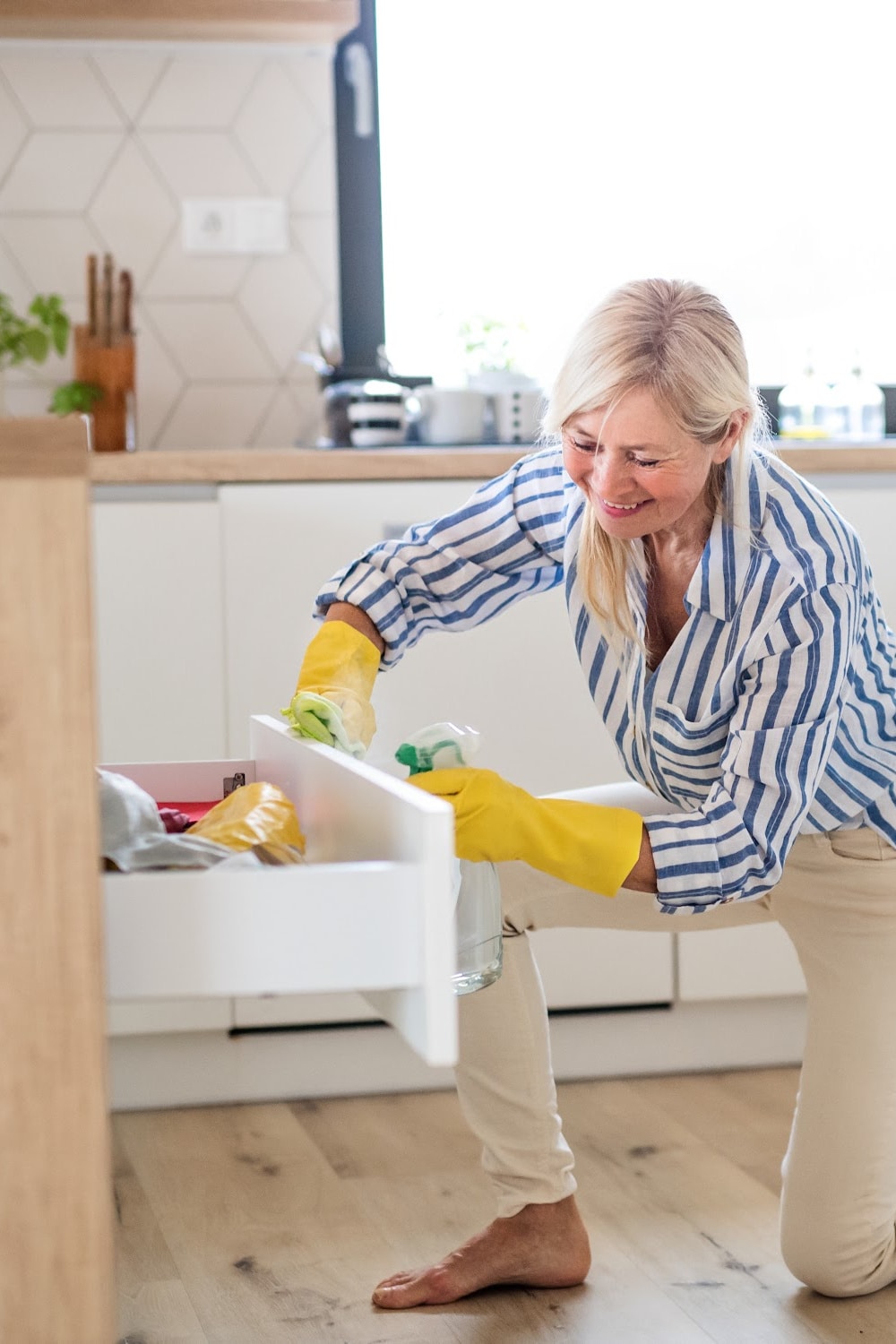 woman cleaning kitchen cabinets