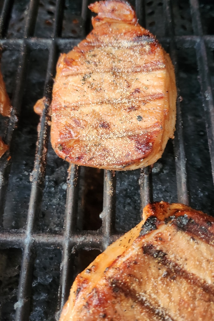grilled pork chop on grill with spices - good pork chop