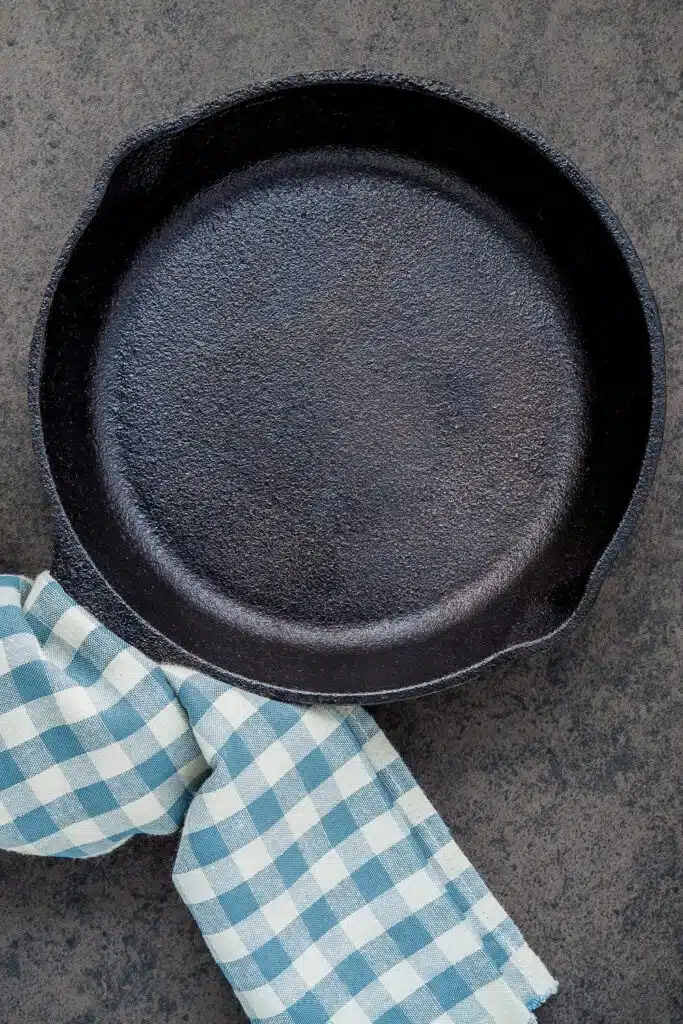 cleaning cast iron skillet - pictured Iron skillet with blue and white checked towel