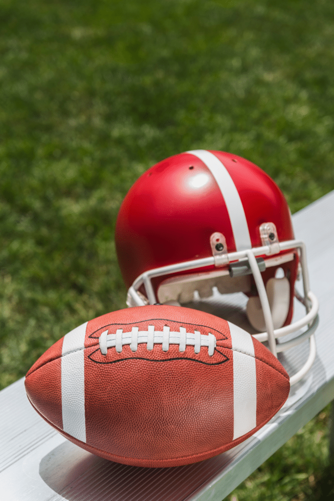 Football and helmet on stadium seat