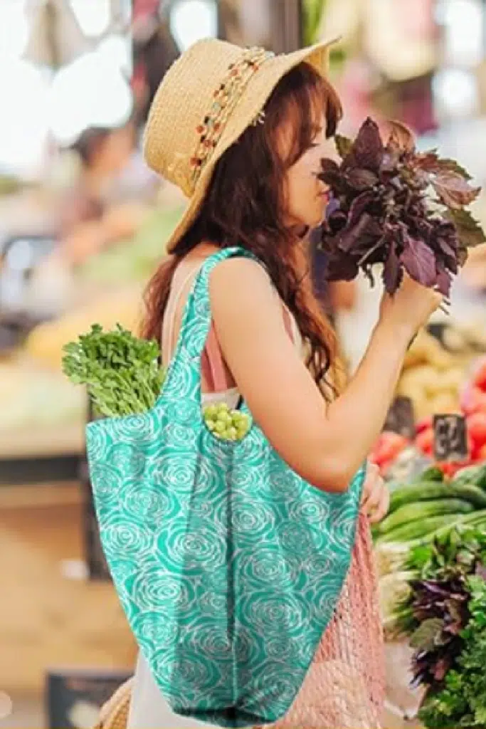 Nylon grocery bag - woman in grocery store shopping with reusable bag