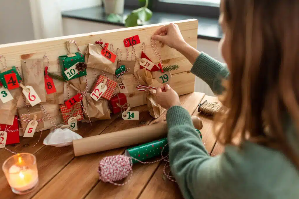 Little girl opening up advent calendar gift