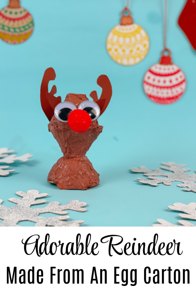 Pictured adorable reindeer craft made from egg carton on blue background