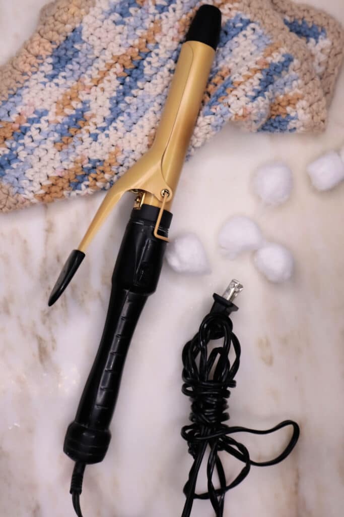 Clean curling iron on marble top background