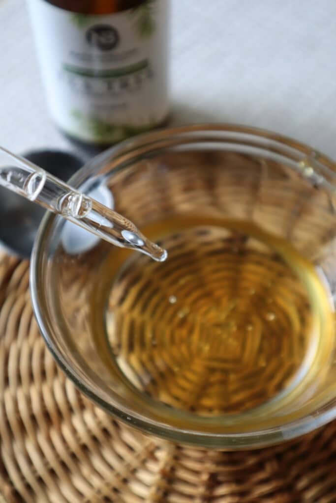 adding essential oils to small glass bowl