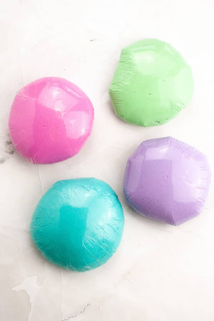 four balls of play dough wrapped in plastic wrap