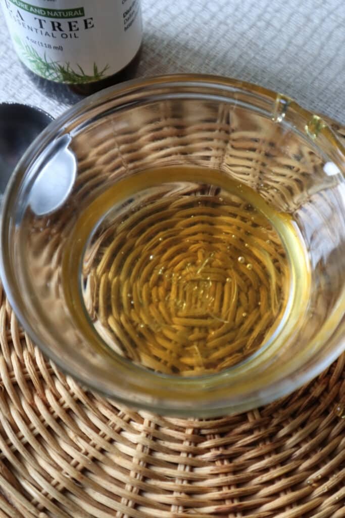 melted coconut oil and honey mixed together in clear glass bowl