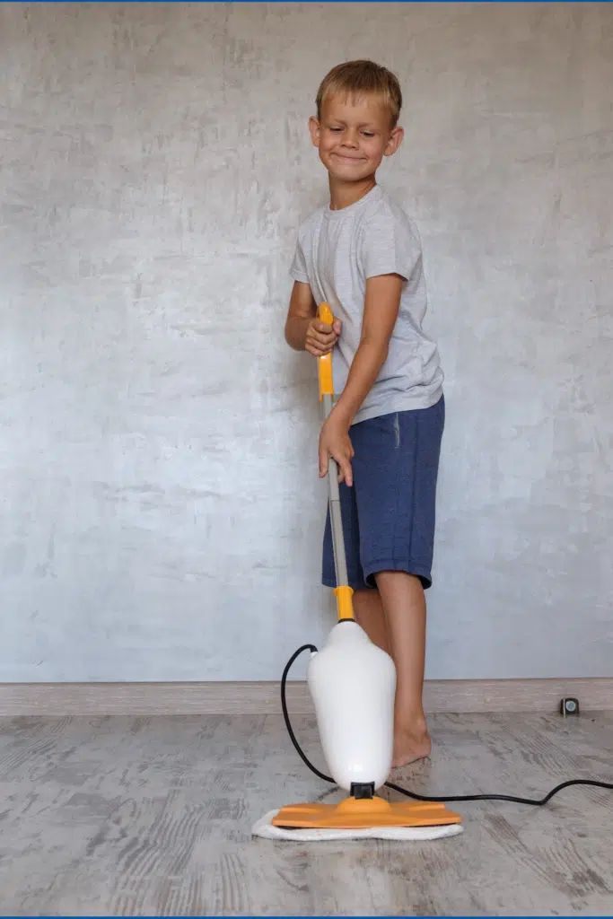 Steam Mop uses hot water to clean surfaces. Little boy cleaning floor