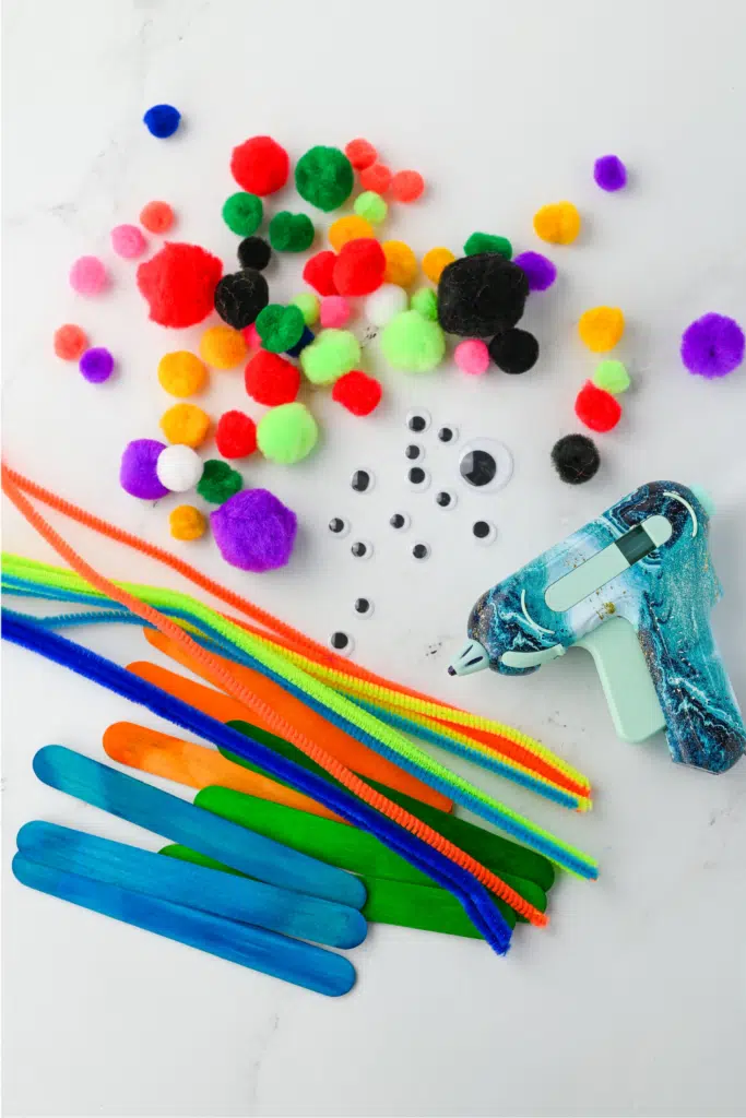 Supplies needed for Monster kids bookmarkers - pictured hot glue gun, pipe cleaners, etc