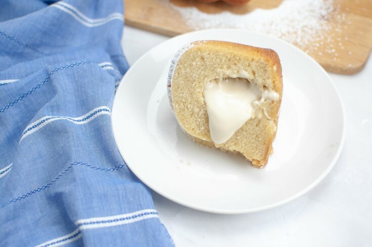 Twinkie Bundt Cake - one slice with marshmallow filling on white plate ready for serving