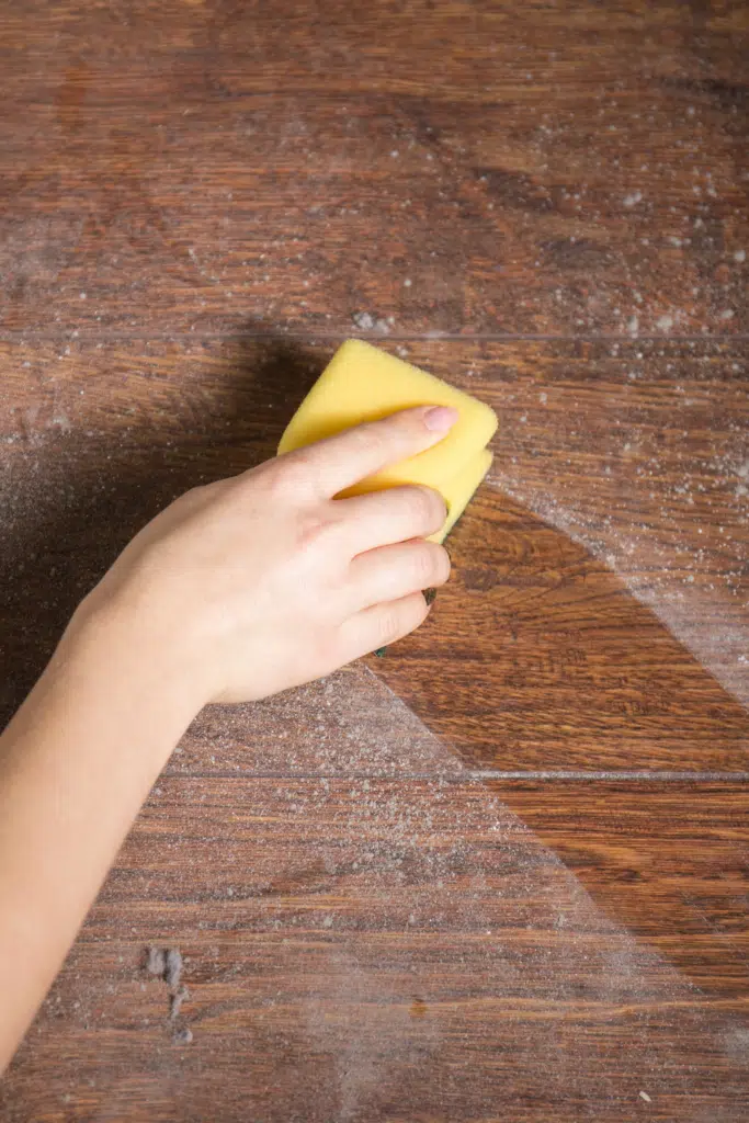 Dusty tabletop with woman cleaning dust off - Dust buildup