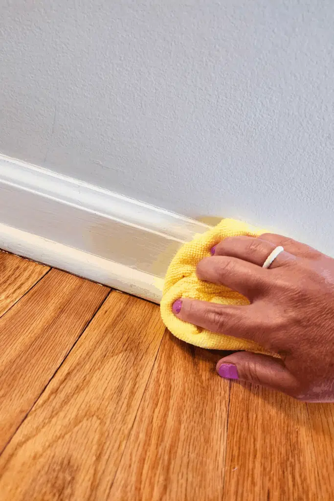 Dusting baseboards with microfiber cloth