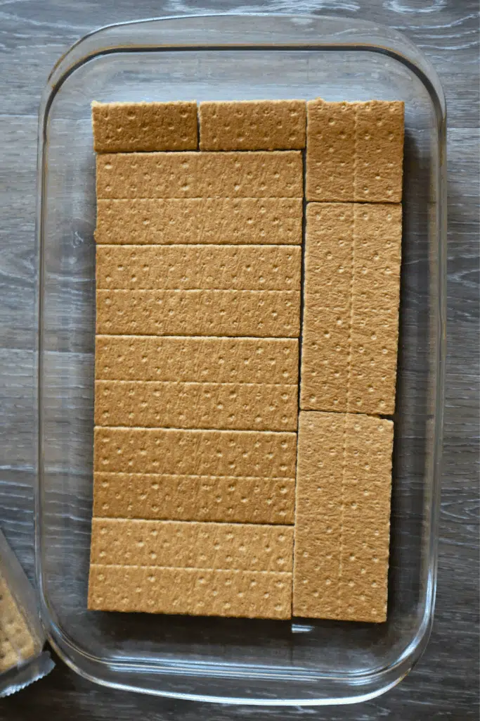 graham crackers laid out in glass casserole pan