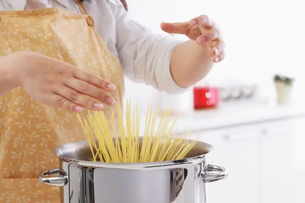 Adding pasta to pot Photo Credit Canva Pro Stock Image