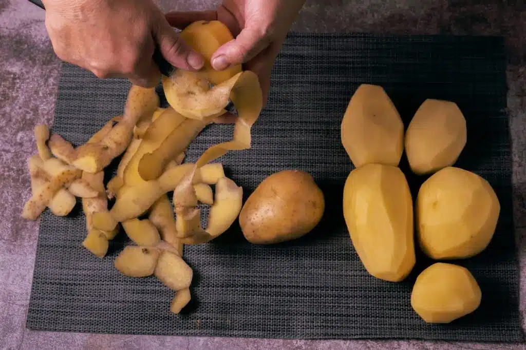 Peeling potatoes with a knife Photo Credit Canva Pro Stock Image