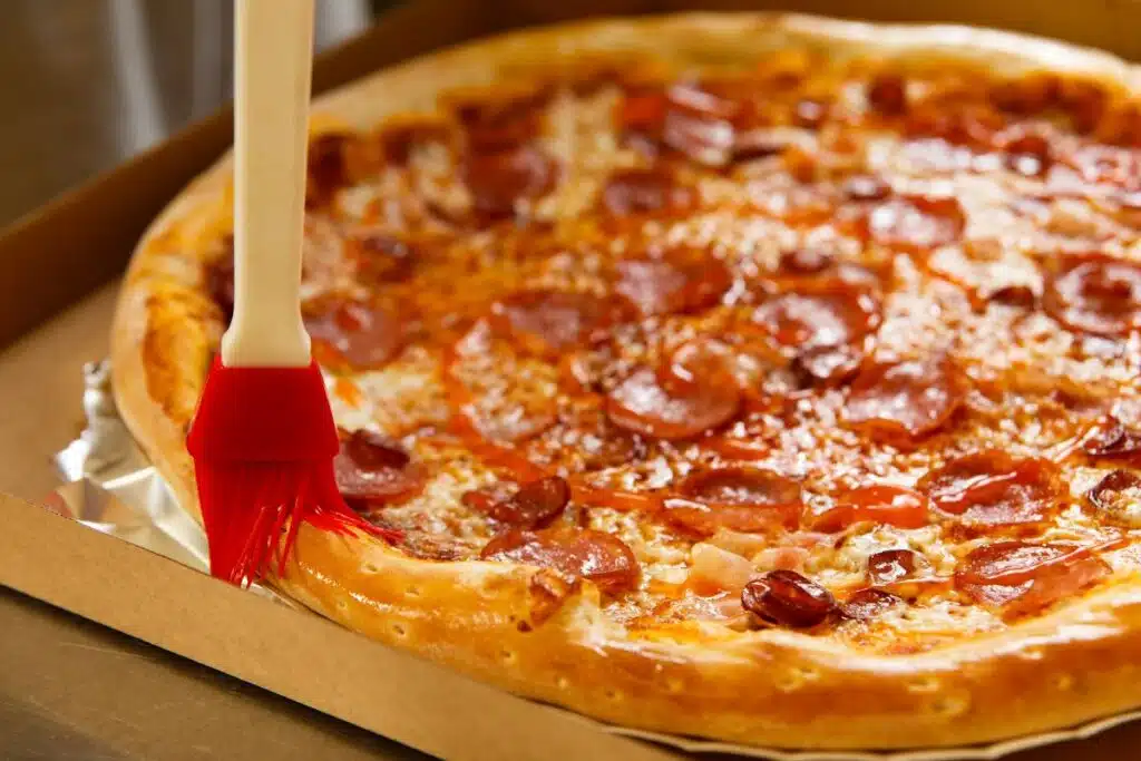 brushing pizza with oil Photo Credit Canva Pro Stock Image